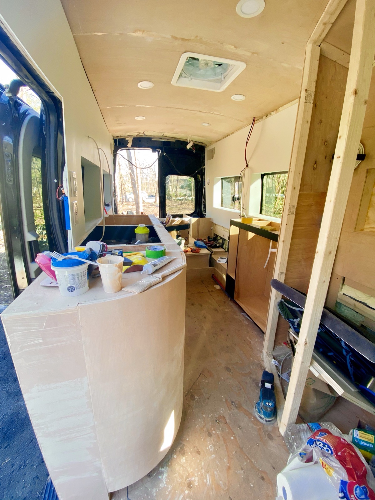 The curved counter mid-finish, surrounded by paint cups and tools