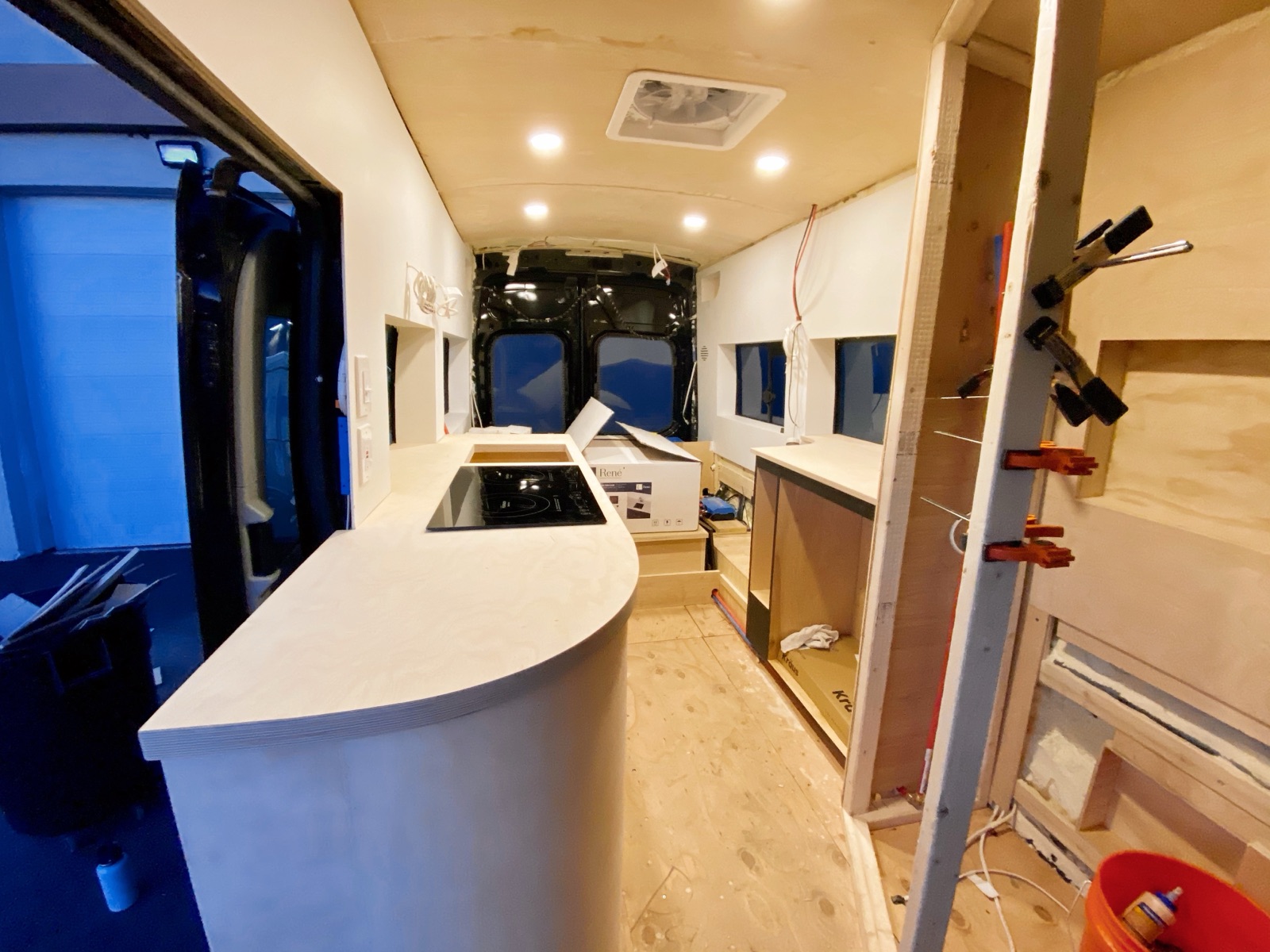 The curved white galley counter with clamps and tools nearby