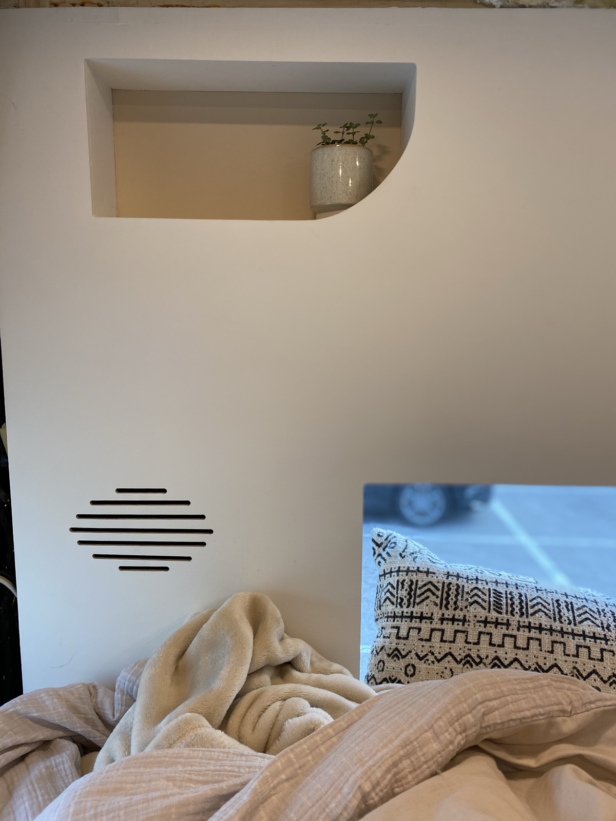 The arched niche above the made-up bed